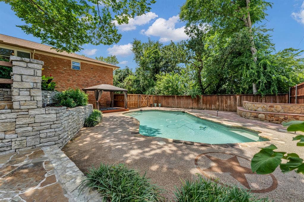 3908 Wildwood, Euless, TX 76040 Backyard oasis featuring a freeform swimming pool, decorative concrete patio, and a covered gazebo