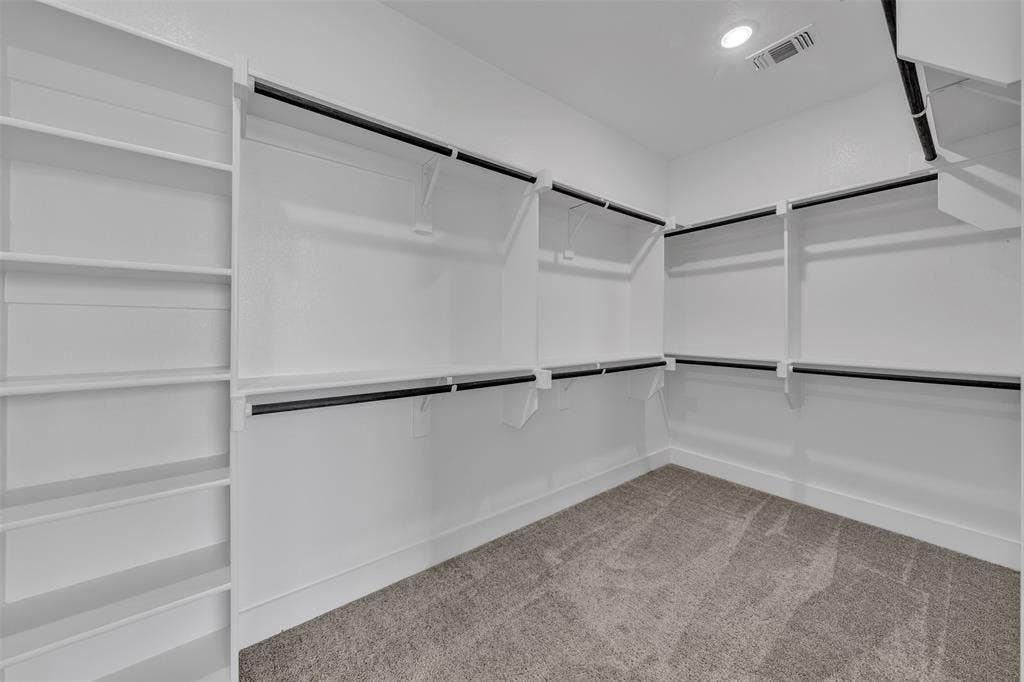 2004 Willy Dilly Road, Springtown, TX 76082 Walk-in closet featuring built-in shelving, multiple hanging rods, white walls, and a recessed ceiling light