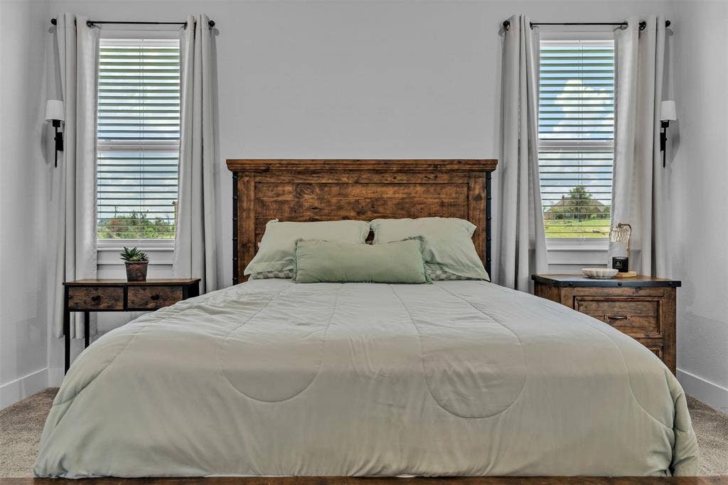 2004 Willy Dilly Road, Springtown, TX 76082 Spacious bathroom with a walk-in shower featuring a built-in bench, a separate soaking tub, a long double vanity with white cabinetry and dark hardware, a large wall-mounted mirror, and tile flooring