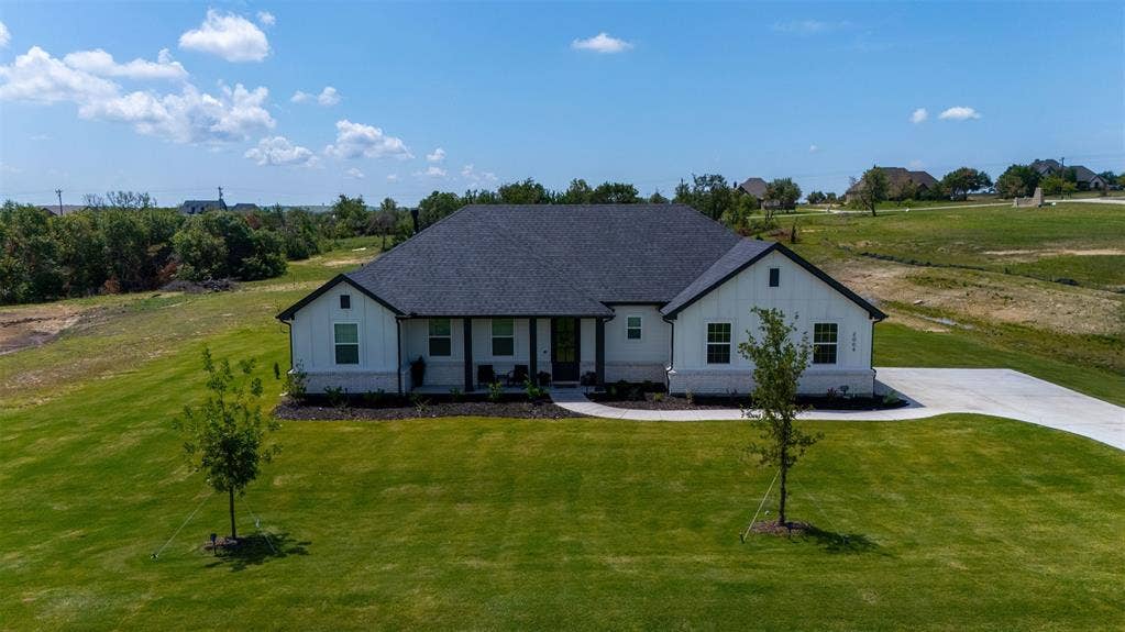 2004 Willy Dilly Road, Springtown, TX 76082 Modern farmhouse exterior with white vertical siding and dark trim