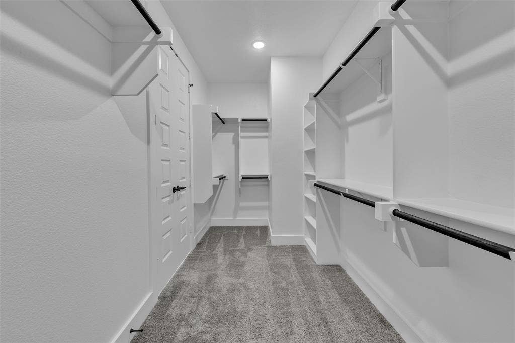 2004 Willy Dilly Road, Springtown, TX 76082 Spacious walk-in closet featuring white built-in shelving, hanging rods, and textured carpeting