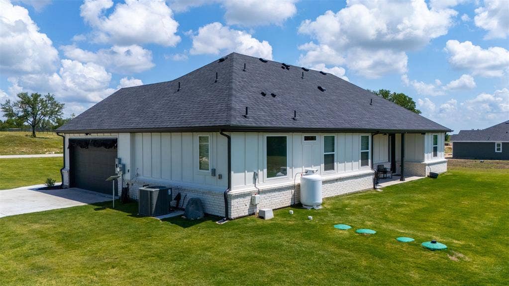 2004 Willy Dilly Road, Springtown, TX 76082 Exterior featuring a dark shingle roof, white vertical siding, and a partial white brick facade