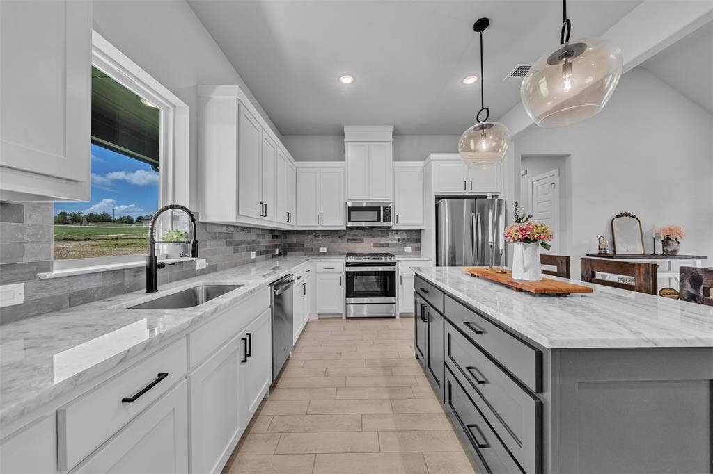 2004 Willy Dilly Road, Springtown, TX 76082 Modern kitchen featuring a two-tone design with white perimeter cabinetry and a dark gray island