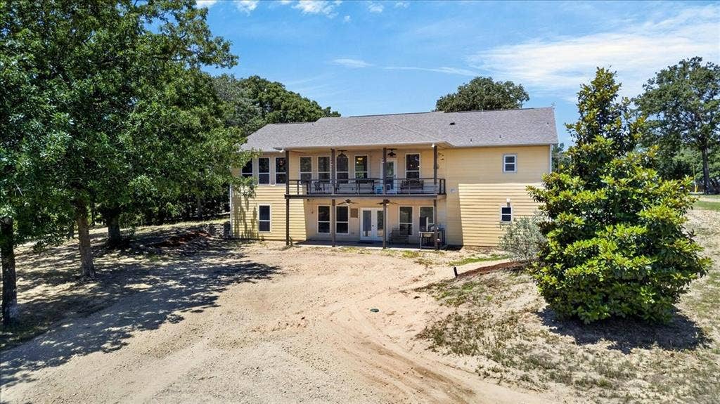 11591 Farm Market 59, Athens, TX 75751 Two-story residence with a light tan exterior and a gray shingle roof