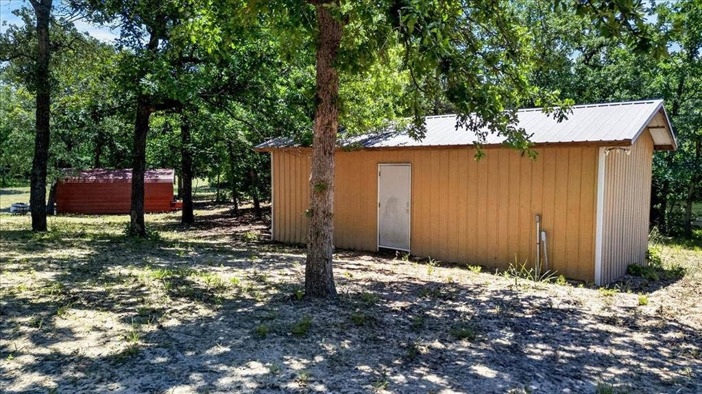 11591 Farm Market 59, Athens, TX 75751 Workshop with electric, featuring vertical panel siding, a single entry door, and a metal roof