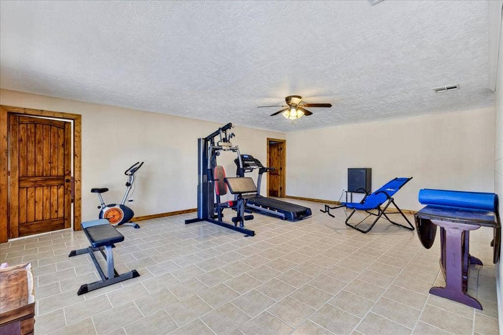 11591 Farm Market 59, Athens, TX 75751 Basement Flex space room featuring neutral-toned walls, tile flooring, and rustic wood-paneled doors. Right now this multi-purpose space is the exercise room - BUT what would you do with this Bonus space?