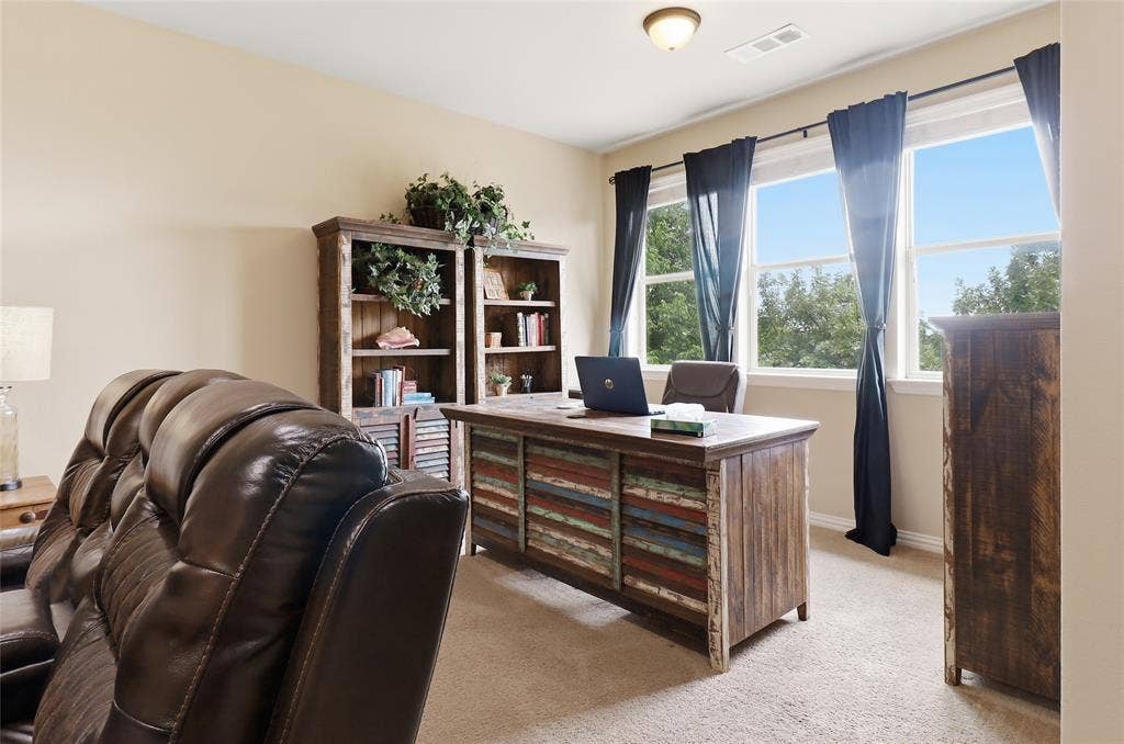 6905 Denali Drive, McKinney, TX 75070 Bright room featuring multiple windows with tree-lined scenery, beige wall tones, and carpet flooring