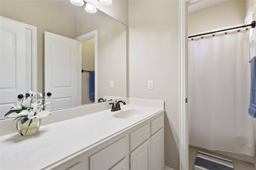6905 Denali Drive, McKinney, TX 75070 Spacious vanity with an integrated sink, broad mirror, and built-in cabinetry