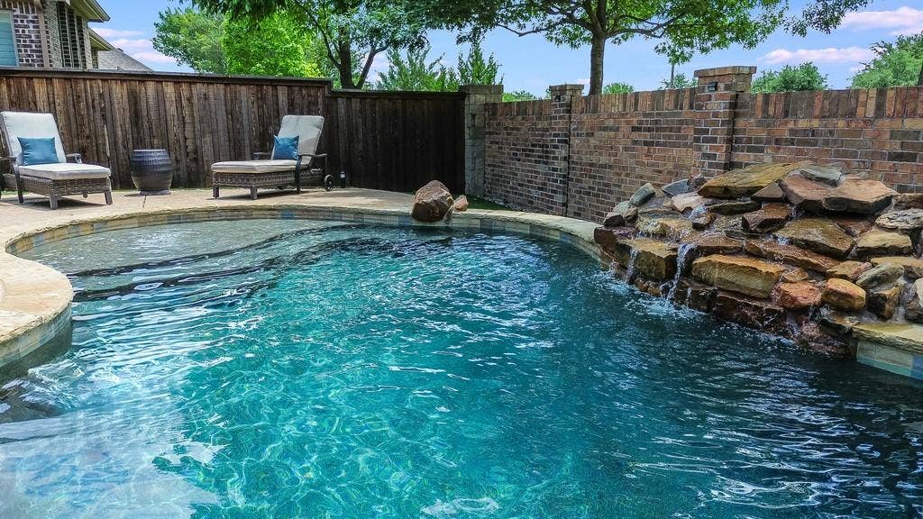 6905 Denali Drive, McKinney, TX 75070 Freeform swimming pool with integrated rock waterfall feature