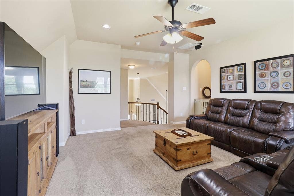 6905 Denali Drive, McKinney, TX 75070 UpstairsCarpeted living area featuring a ceiling fan with integrated lighting, recessed lighting, and an arched doorway