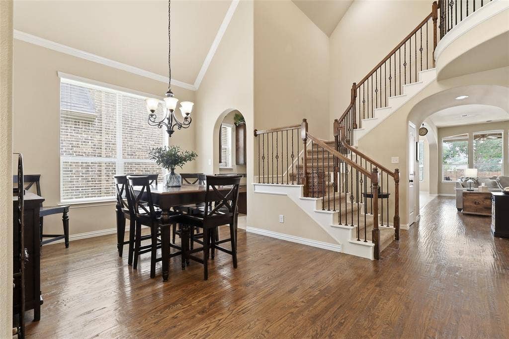 6905 Denali Drive, McKinney, TX 75070 Grand entry with hardwood flooring and a curved staircase featuring wrought iron balusters