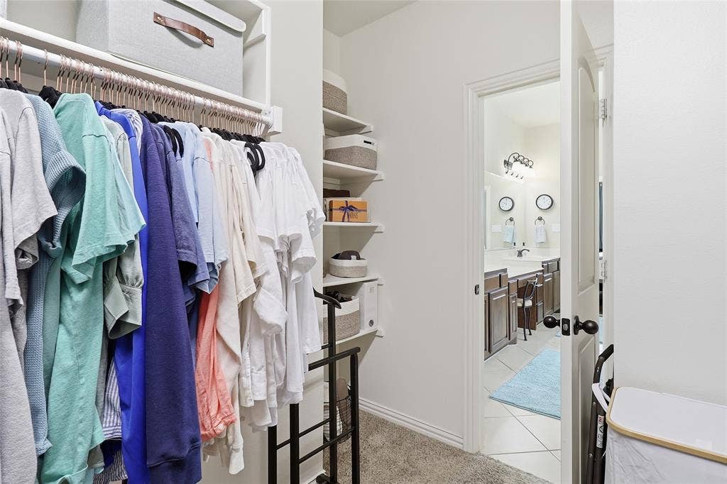 6905 Denali Drive, McKinney, TX 75070 Walk-in closet featuring extensive hanging space, built-in shelving, and carpeted flooring