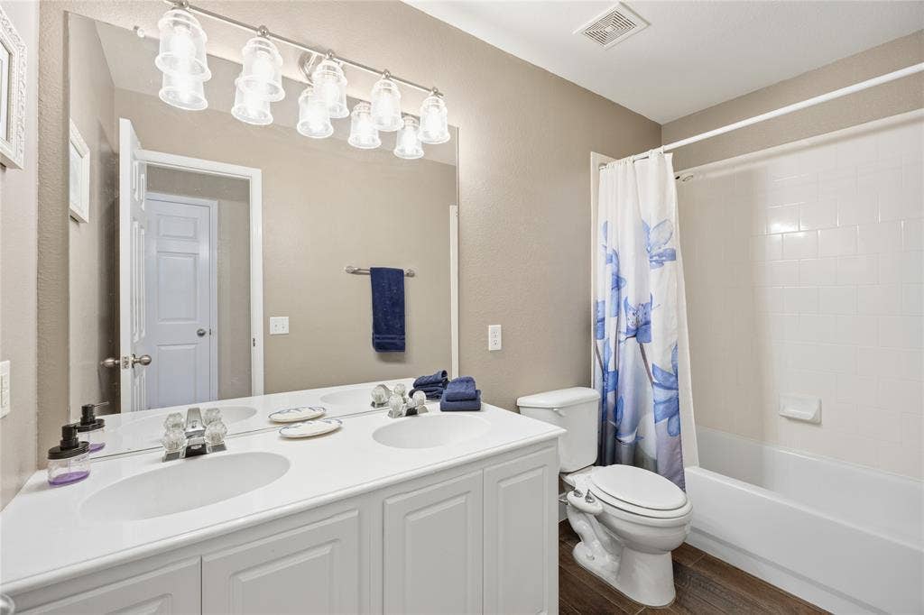 Dual vanity with integrated sinks, brushed nickel fixtures, and a multi-bulb light bar