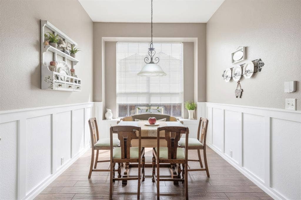 Dining space featuring wood-finish flooring and wainscoting