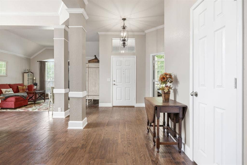 Spacious entryway featuring wood-finish flooring, a recessed ceiling, and a decorative pendant light fixture