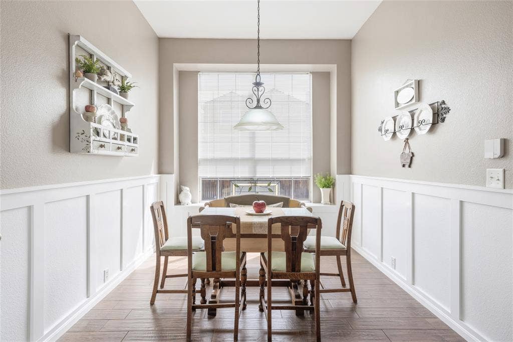 Wood-finish flooring throughout, complemented by crisp white board and batten wainscoting