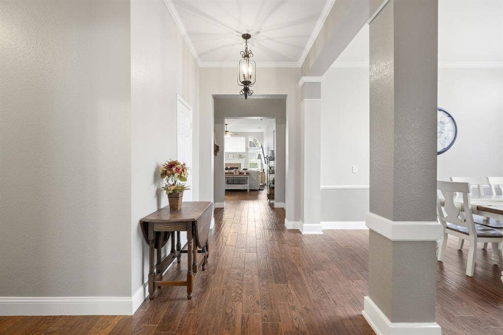 Hallway featuring wood-finish flooring, crown molding, and recessed lighting
