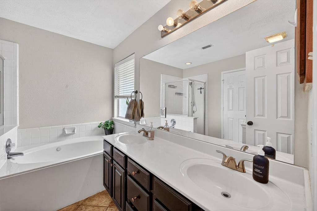 Dual vanity with dark wood-finish cabinetry, white countertops, and undermount sinks