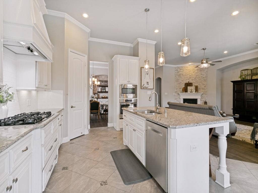 720 Hampshire Drive, Prosper, TX 75078 Kitchen has a gas 5 burner range and built in stainless oven and microwave.