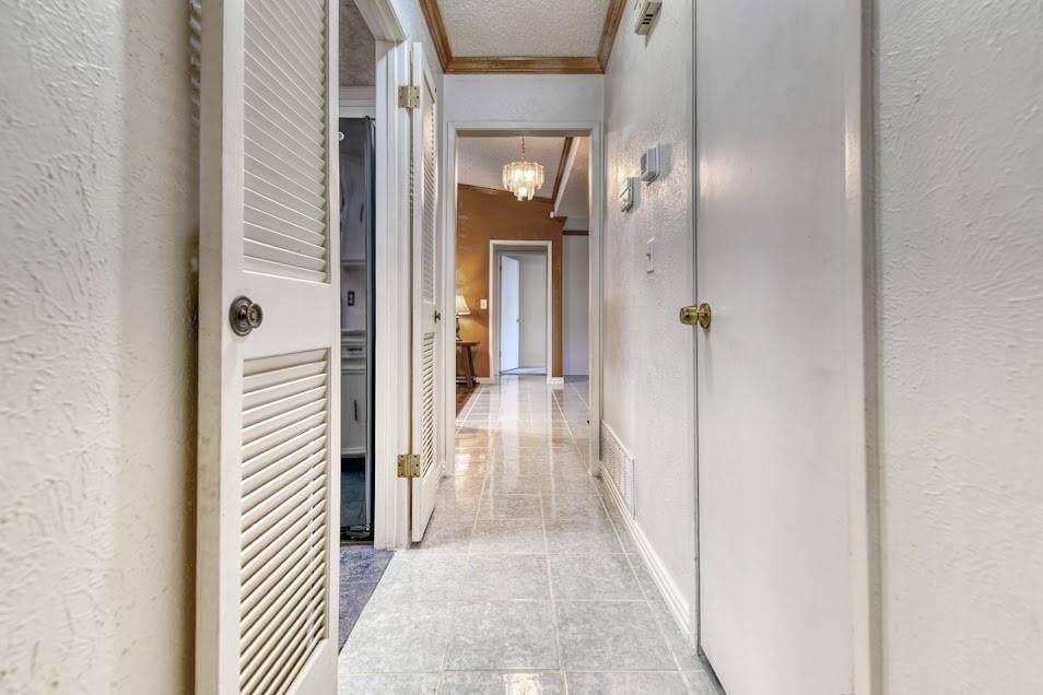 Textured walls, louvered closet doors, and tiled flooring