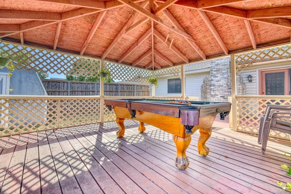 Covered deck featuring exposed beam ceiling with lattice siding, composite decking, and built-in seating areas