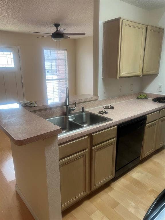 121 Brookside Drive, Duncanville, TX 75137 Kitchen area featuring a stainless steel double basin sink with a gooseneck faucet, tan cabinetry, and a black built-in dishwasher