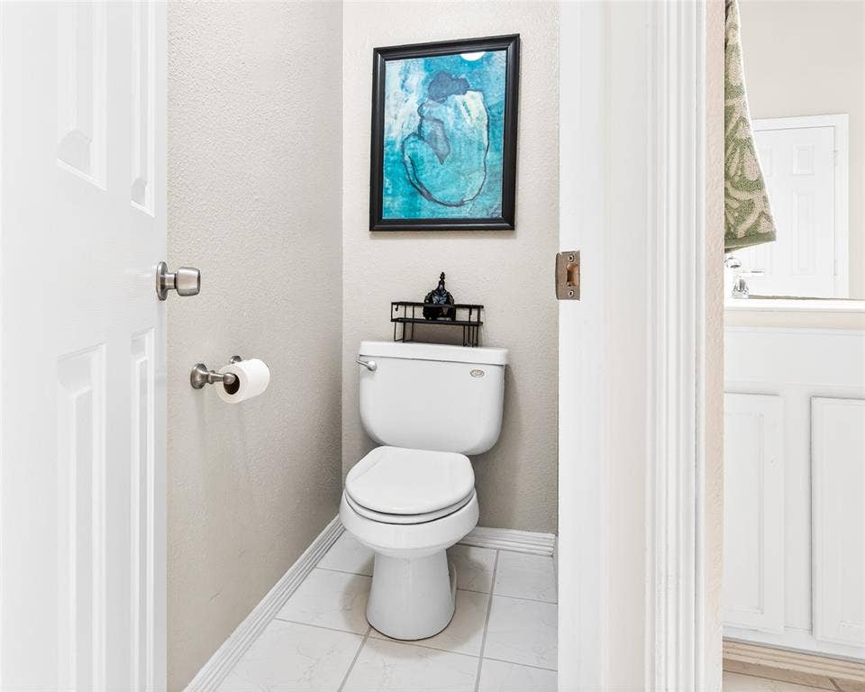 6005 Pin Oak Drive, McKinney, TX 75072 Compact water closet featuring white tile flooring, neutral wall tones, and a white toilet
