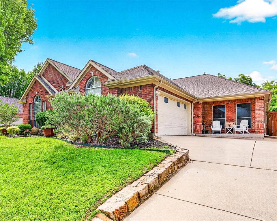 6005 Pin Oak Drive, McKinney, TX 75072 Brick exterior with a gabled roofline, arched windows, and an attached two-car garage