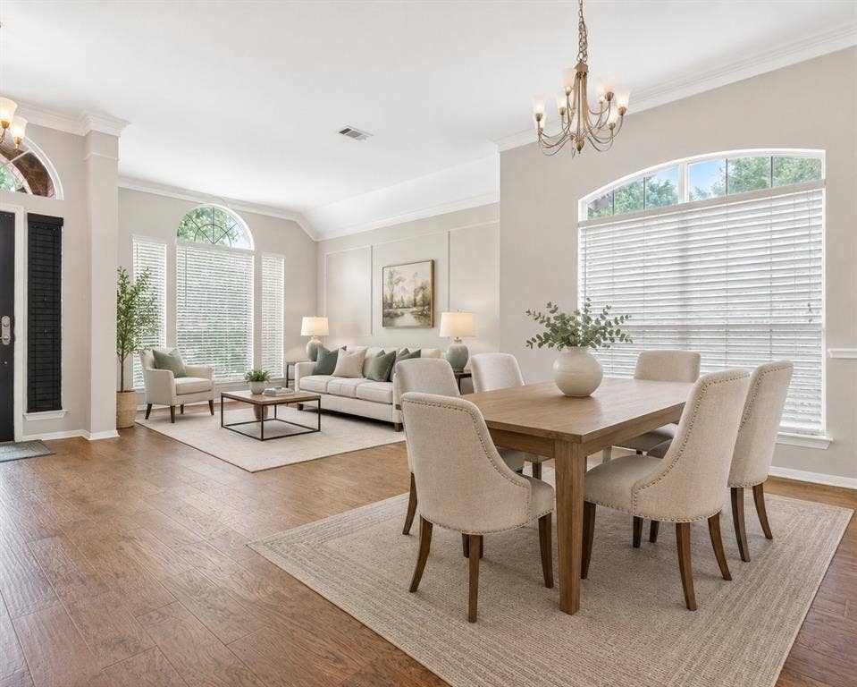6005 Pin Oak Drive, McKinney, TX 75072 Stacked Living and Dining Room Open concept living and dining areas featuring wood-finish flooring, vaulted ceilings, and extensive crown molding