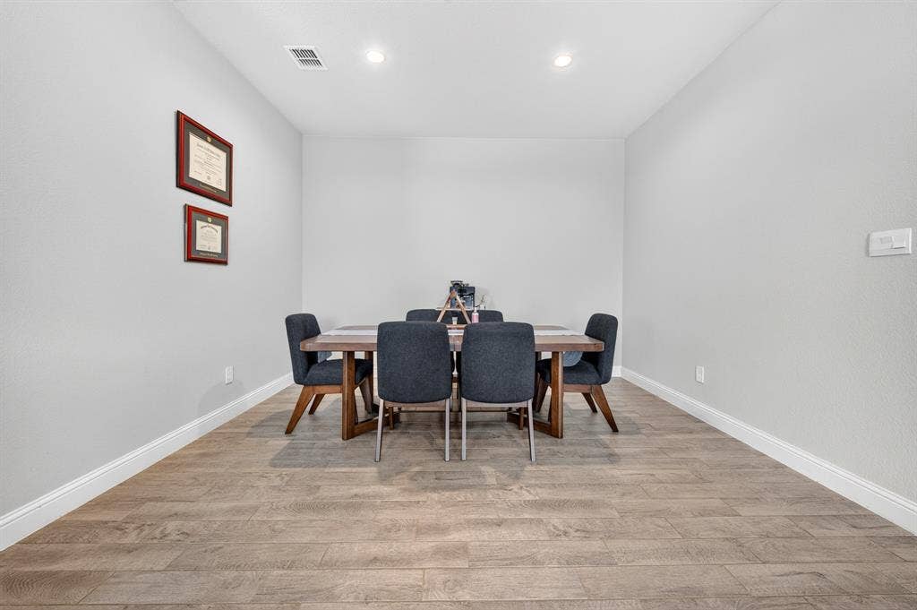 829 Poppie Lane, Midlothian, TX 76065 Recessed lighting illuminates the dining area, featuring wood-finish flooring and white baseboards