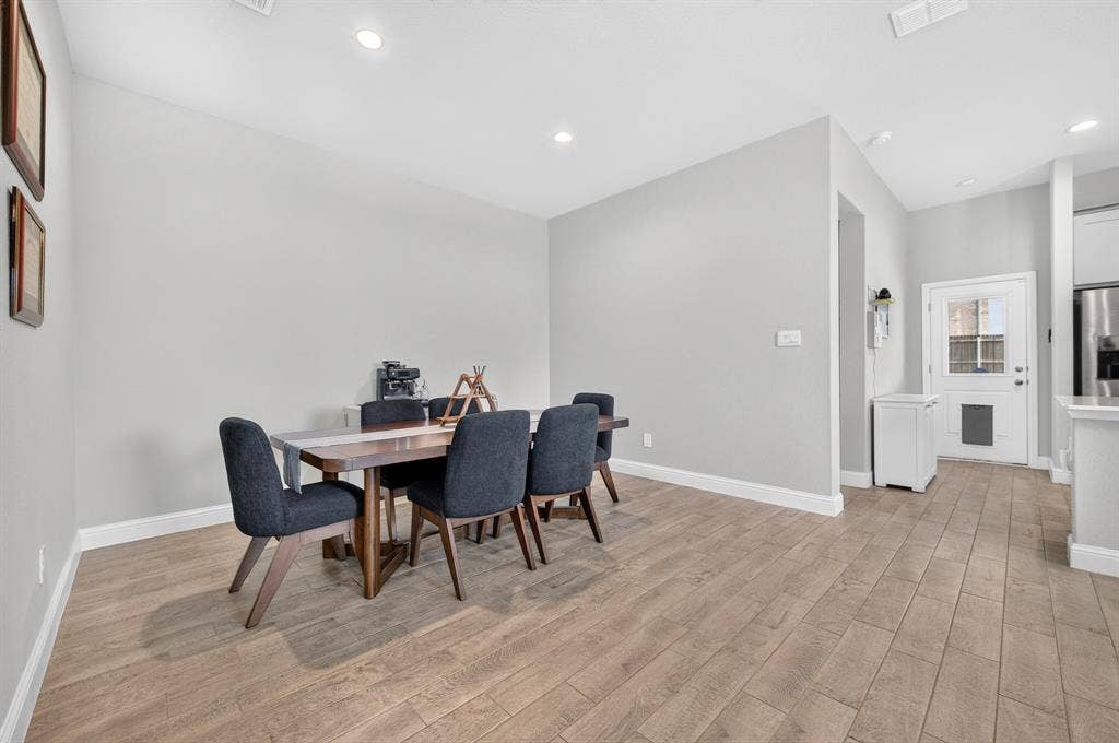 829 Poppie Lane, Midlothian, TX 76065 Open-concept living space featuring wood-finish flooring, recessed lighting, neutral wall tones, white baseboards, and a rear door with a window