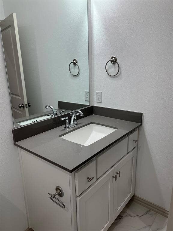 6041 Roper Road, McKinney, TX 75070 Modern vanity featuring a gray countertop, an integrated rectangular sink, and chrome-finish fixtures
