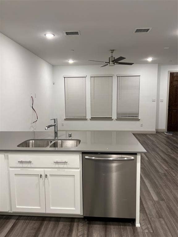6041 Roper Road, McKinney, TX 75070 Kitchen island featuring a double basin stainless steel sink, a stainless steel dishwasher, white shaker cabinetry with brushed nickel hardware, and a solid surface countertop