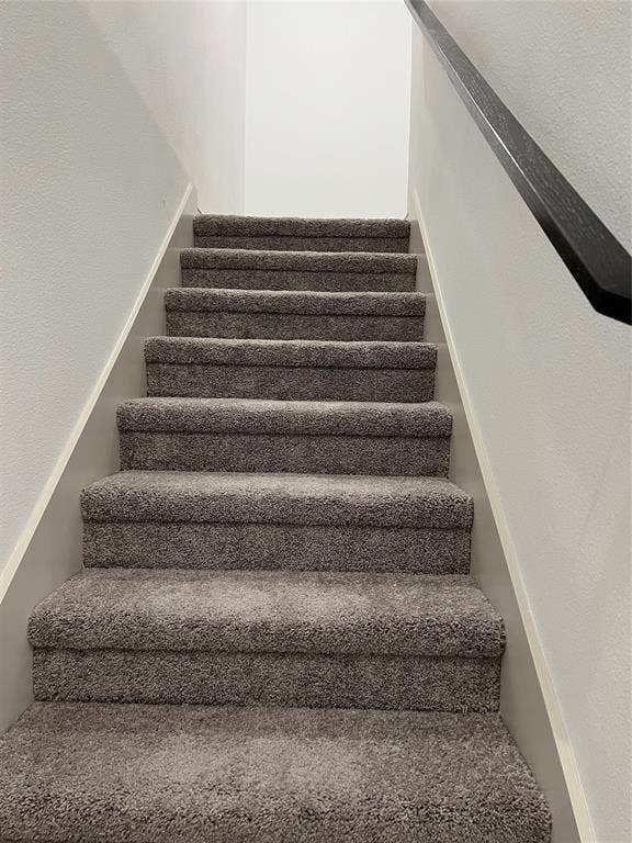 6041 Roper Road, McKinney, TX 75070 Staircase featuring grey plush carpeting and a dark-toned handrail