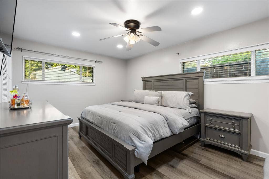 Spacious room featuring wood-finish flooring, recessed lighting, and a ceiling fan