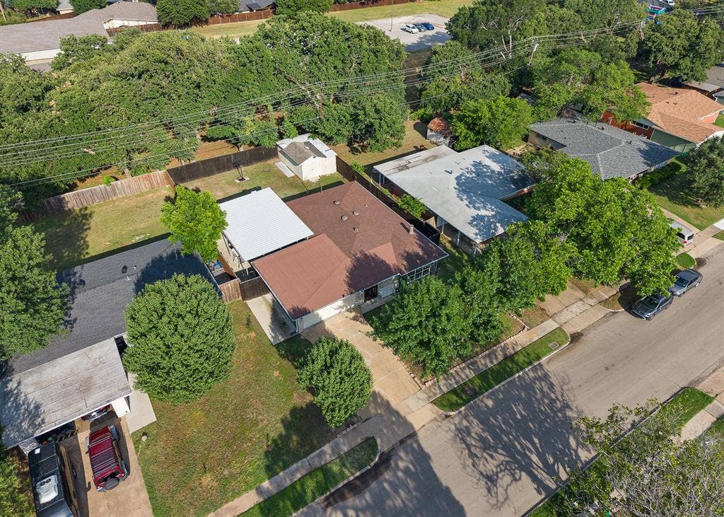 Residential property featuring mature trees, a fenced backyard, and a covered patio area
