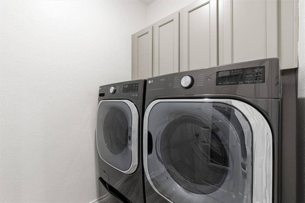 702 Matador Lane, Arlington, TX 76002 Dedicated laundry area featuring a front-loading washer and dryer set