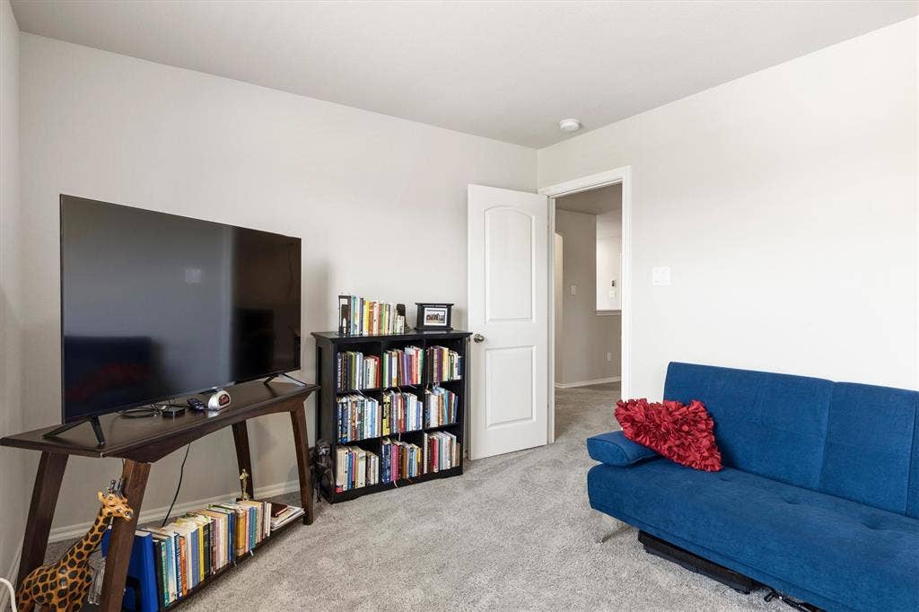 702 Matador Lane, Arlington, TX 76002 Carpeted room with light neutral wall paint, a white interior door, and a built-in ceiling light