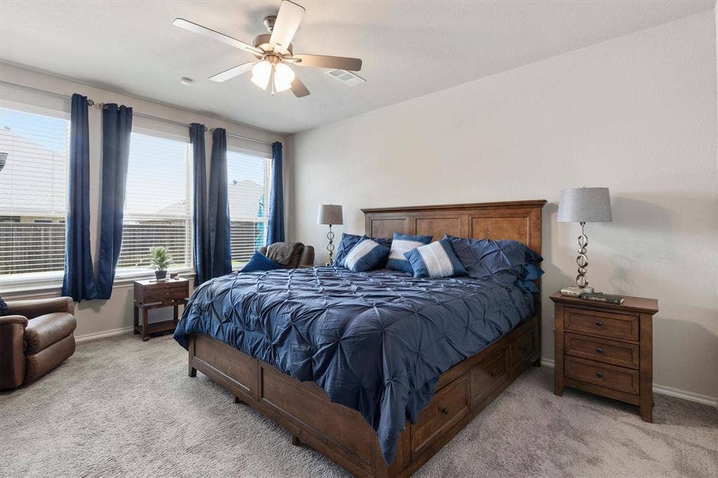 702 Matador Lane, Arlington, TX 76002 Carpeted bedroom featuring a ceiling fan, three windows with blinds, and neutral wall paint