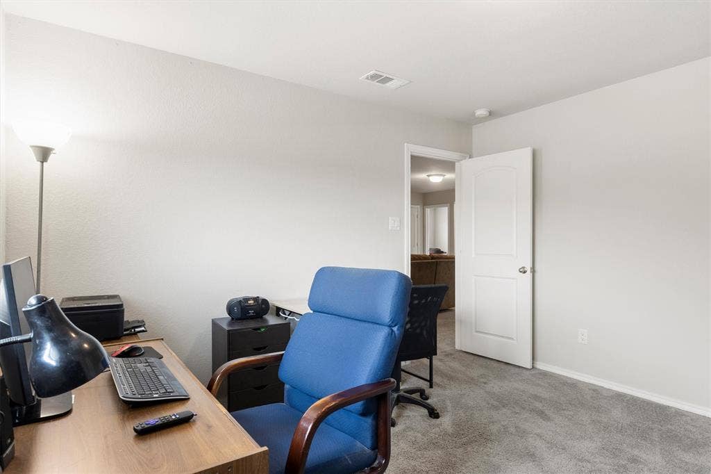 702 Matador Lane, Arlington, TX 76002 Carpeted room with light neutral walls, white baseboards, and a white interior door with a silver-tone handle
