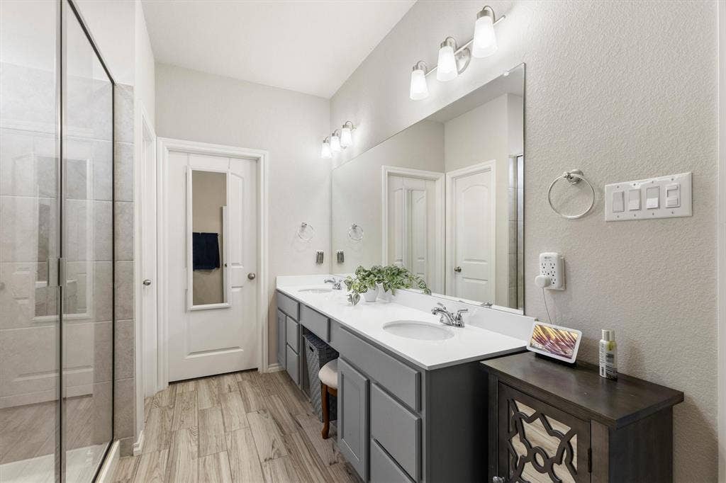 702 Matador Lane, Arlington, TX 76002 Spacious bathroom featuring a dual vanity with white countertops, grey cabinetry, and chrome fixtures