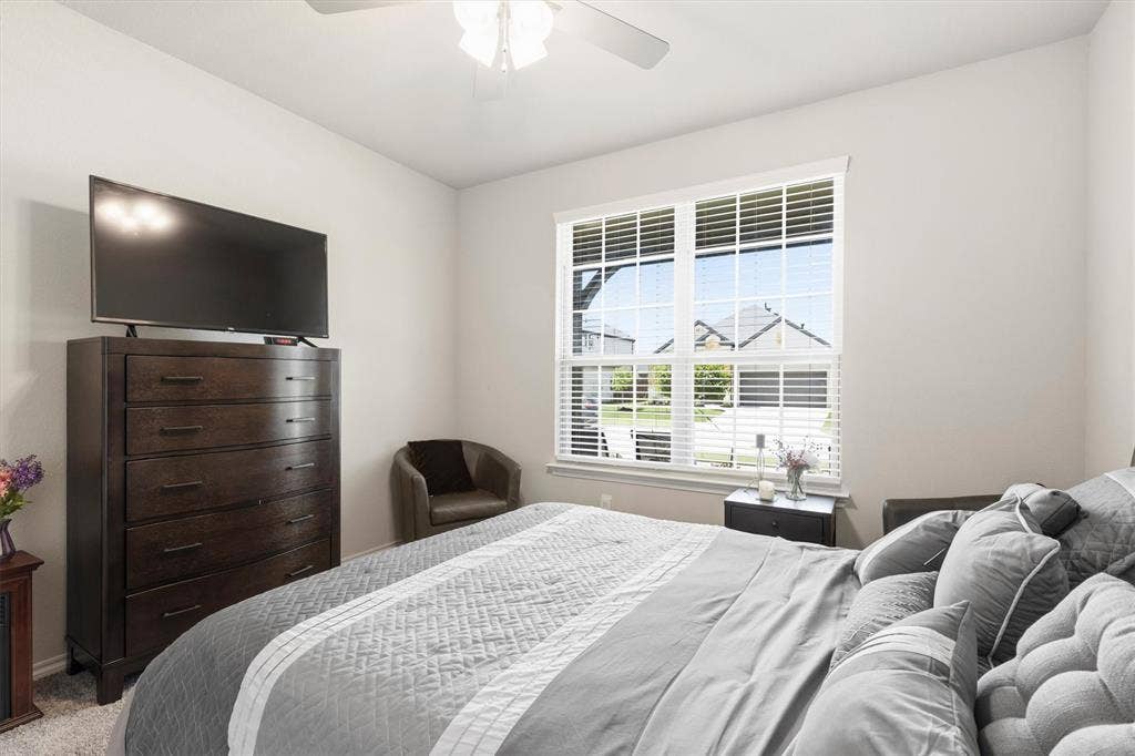 702 Matador Lane, Arlington, TX 76002 Bedroom featuring light-colored walls, a ceiling fan with light fixture, and carpeted flooring