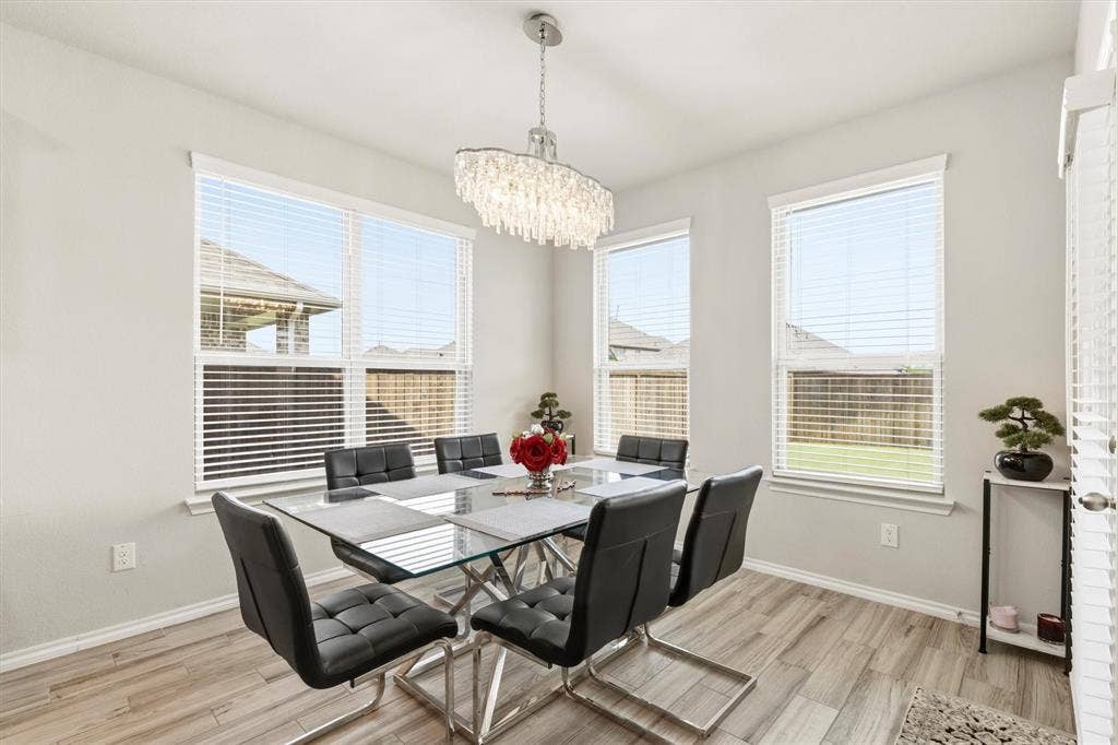 702 Matador Lane, Arlington, TX 76002 Spacious dining area featuring wood-finish flooring and multiple windows with blinds