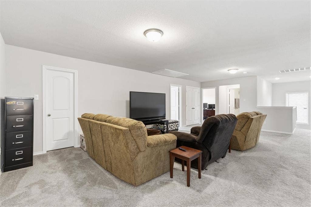 702 Matador Lane, Arlington, TX 76002 Spacious carpeted room featuring light gray walls, multiple interior doors, and a partial low wall opening