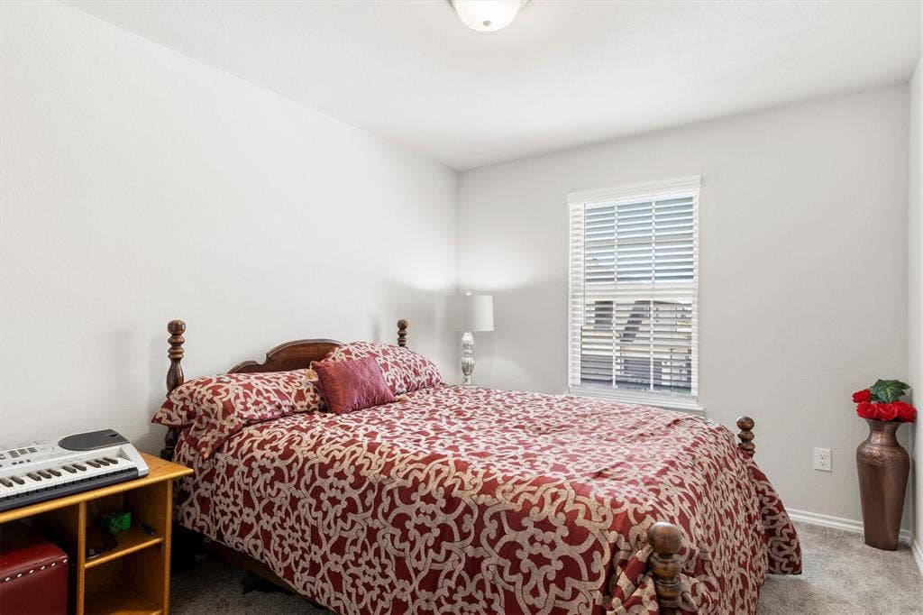 702 Matador Lane, Arlington, TX 76002 Bedroom featuring light gray walls, plush gray carpet, and a window with white blinds