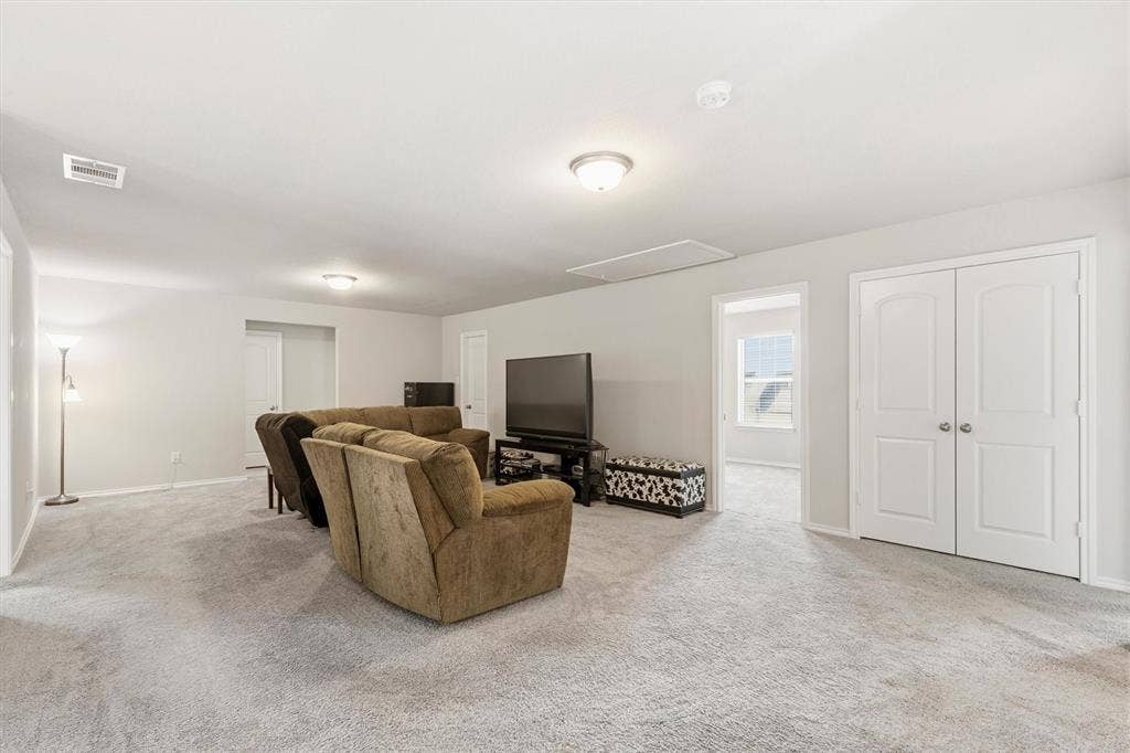 702 Matador Lane, Arlington, TX 76002 Spacious carpeted room featuring light gray walls, white trim, and a ceiling-mounted light fixture