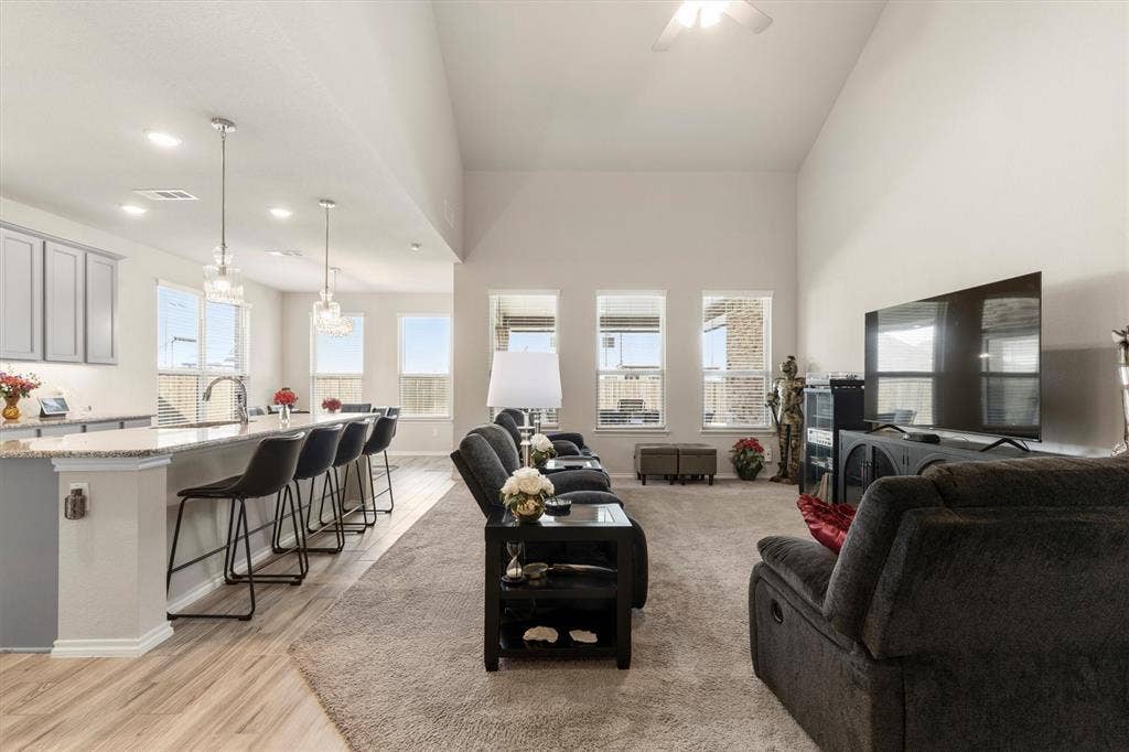 702 Matador Lane, Arlington, TX 76002 Open-concept living area featuring a vaulted ceiling and an integrated kitchen with gray cabinetry