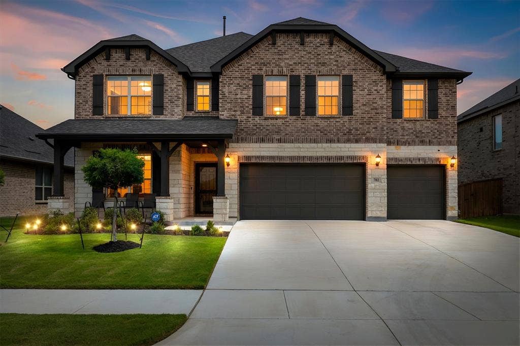 702 Matador Lane, Arlington, TX 76002 Two-story brick and stone facade with dark shutters and a covered entry porch