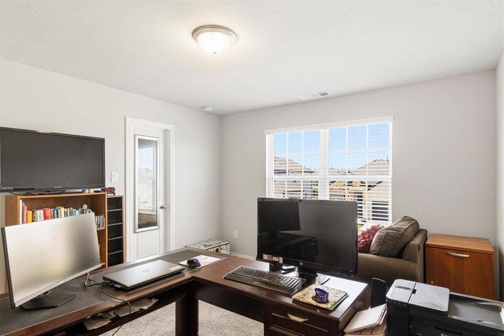 702 Matador Lane, Arlington, TX 76002 Bright room featuring a large window with blinds, carpeted flooring, and a ceiling-mounted light fixture