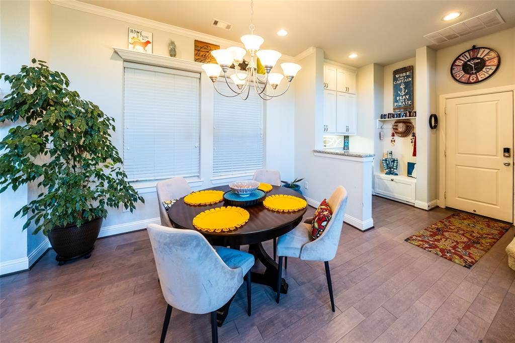 Dining area featuring wood-finish flooring and a contemporary chandelier
